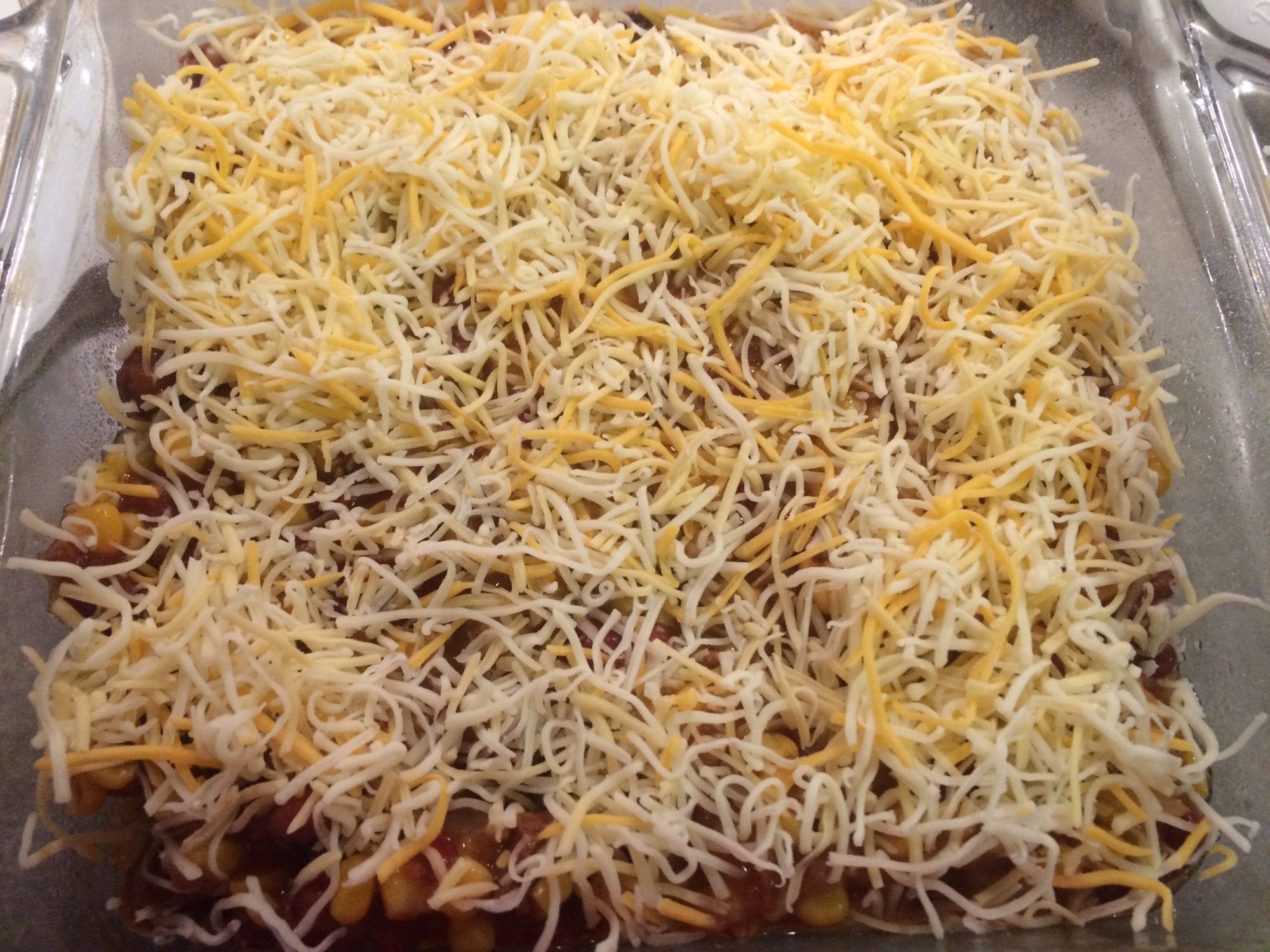 Sprinkle cheese on Mexican Chili Cornbread Casserole.