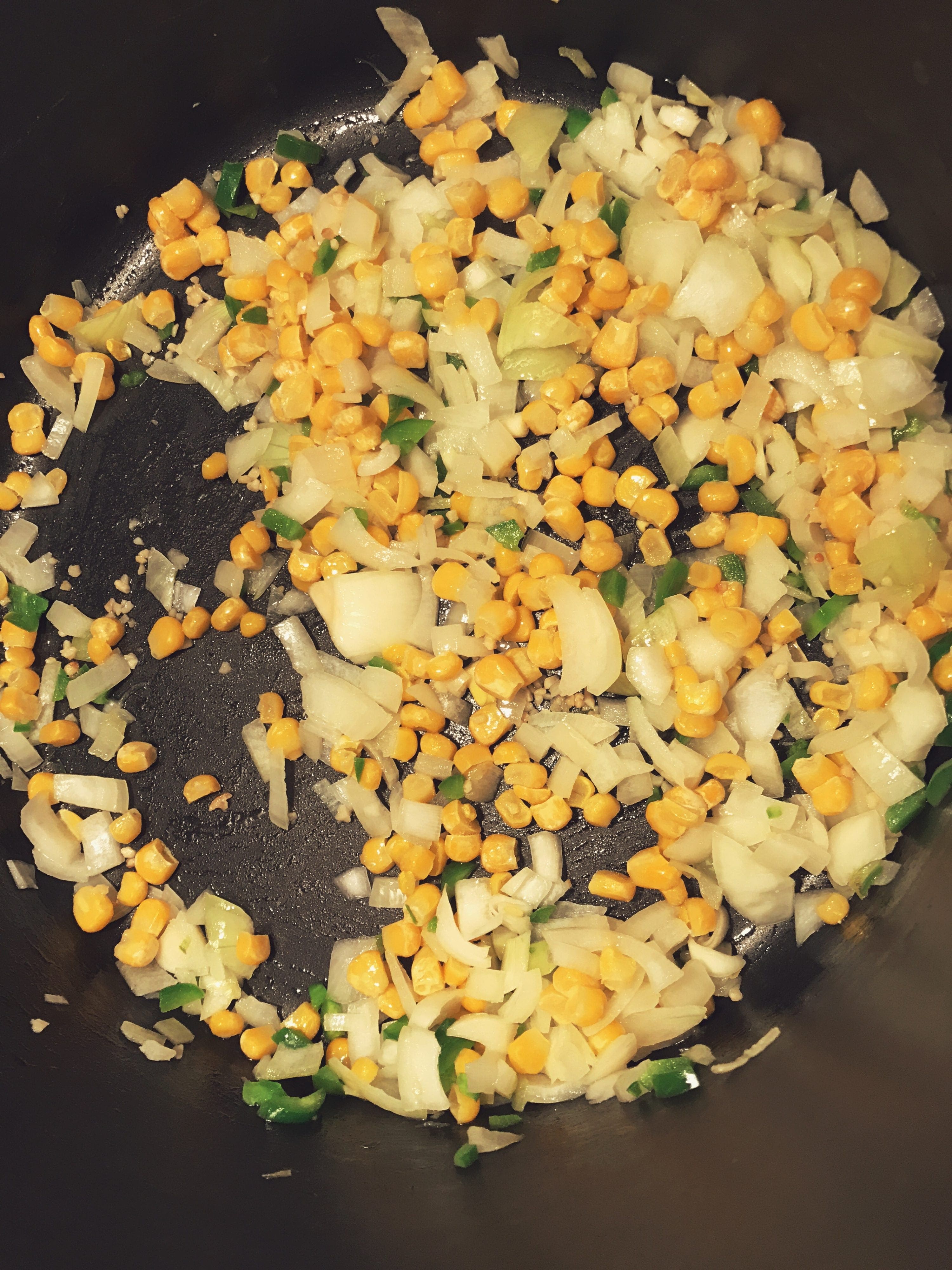 Cooking onion, jalapeno, garlic, and corn