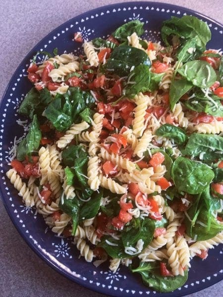 Alisha's favorite Bruschetta Pasta Salad is a Weight Watchers friendlly healthy take on an old favorite with fresh spinach, tomatoes, basil, pasta, shredded cheese, and vinaigrette. 
