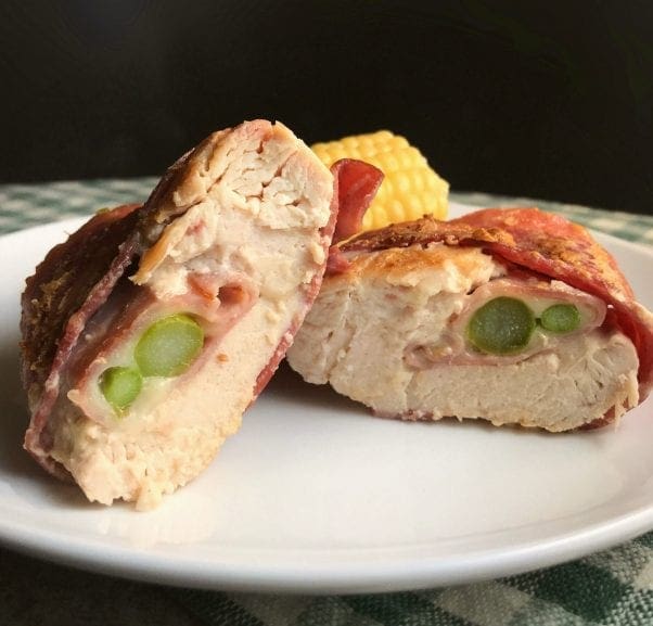 Bacon wrapped chicken roulades includes asparagus, cheese, and ham in the center.