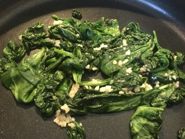Cook the spinach and garlic.