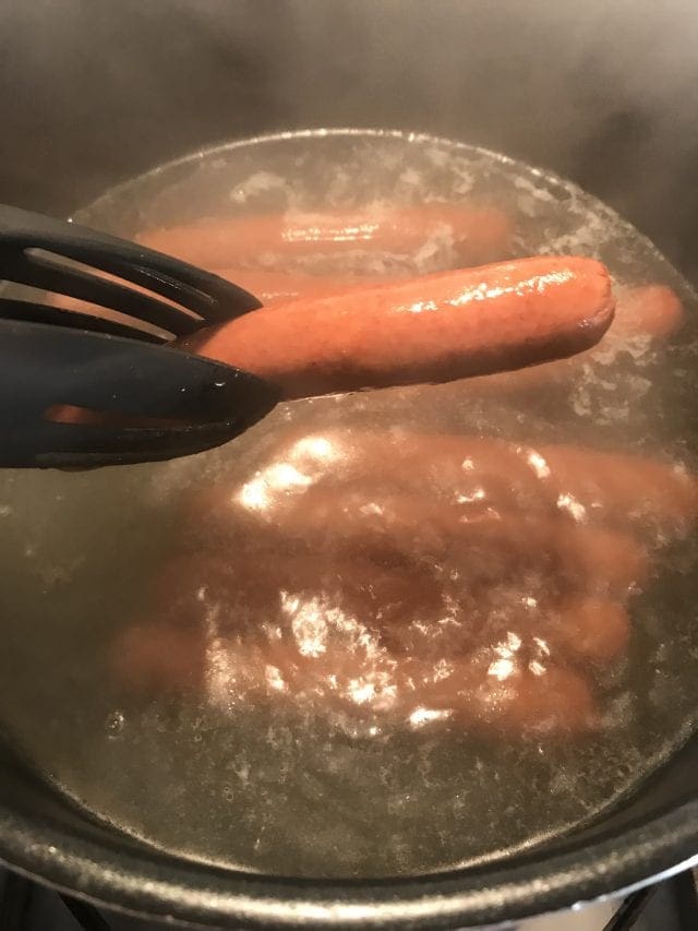 Cook hot dogs in boiling water.