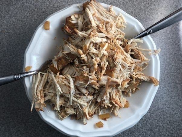 Shred the chicken from the slow cooker using 2 forks.