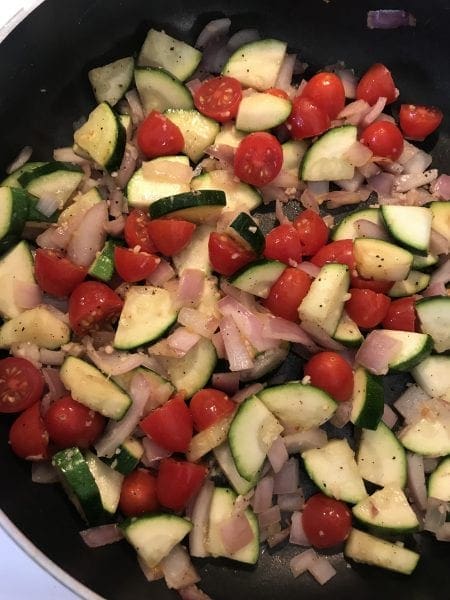 Add cherry tomatoes to the zucchini and red onion.