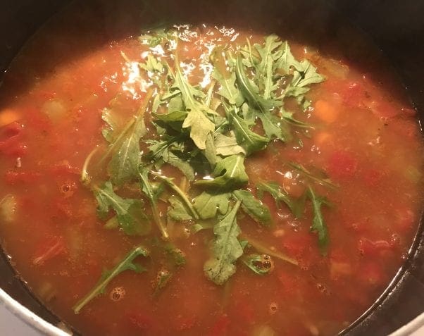 Allow the spinach or arugula to wilt in the soup.